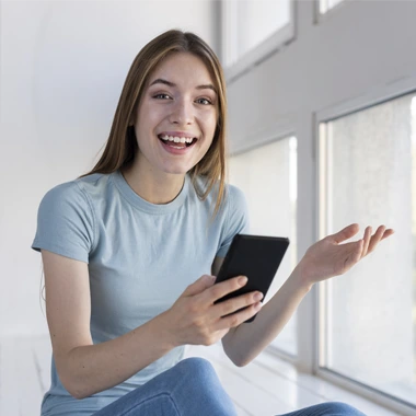 ragazza che sorride mentre usa il suo smarthphone