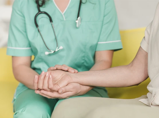 infermiere che tiene la mano di un paziente